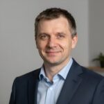 Портрет уверенного российского бизнесмена с дружелюбным взглядом на размытом нейтральном фоне в студии